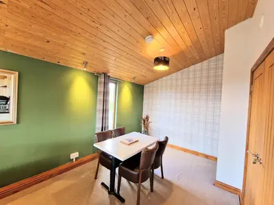 a dining room with a table and chairs at Ochil 8 with Private Hot Tub - Fife - Loch Leven - Lomond Hills in Kelty