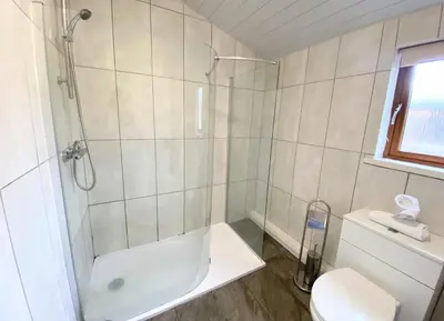 a bathroom with a shower and a toilet and a sink at Ochil 10 with Private Hot Tub - Fife - Loch Leven - Lomond Hills in Kelty