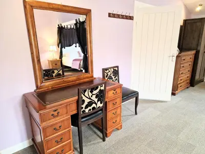 a bedroom with a dresser with a mirror on it at Ochil 10 with Private Hot Tub - Fife - Loch Leven - Lomond Hills in Kelty