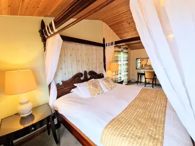 a bedroom with a large bed with a wooden headboard at Lomond 3 with Private Hot Tub - Fife - Loch Leven - Lomond Hills -Pet Friendly in Kelty