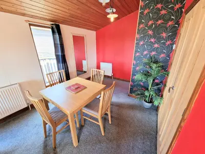 a dining room with a table and chairs and a plant at Lomond 4 with Private Hot Tub - Fife - Loch Leven - Lomond Hills in Kelty