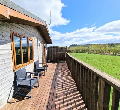 a wooden deck with chairs on a house at Lomond 4 with Private Hot Tub - Fife - Loch Leven - Lomond Hills in Kelty