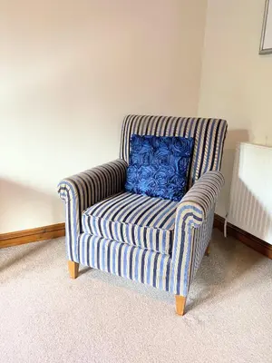 a blue pillow on a striped chair in a room at Lomond 5 with Private Hot Tub - Fife - Loch Leven - Lomond Hills - Pet Friendly in Kelty