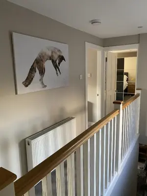 a staircase with a painting of a bear on the wall at Garron House in Auchterarder