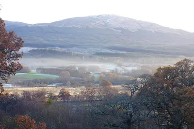 a misty valley with a mountain in the background at Cosy & compact Rowan Lodge no4 in Killin