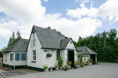 a white house with a black roof at Glenview Luss in Luss