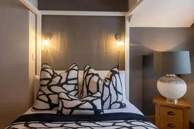 a bedroom with a bed with black and white pillows at Glenview Luss in Luss