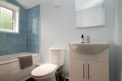 a bathroom with a white toilet and a sink at Upper Alta Apartment in Tighnabruaich