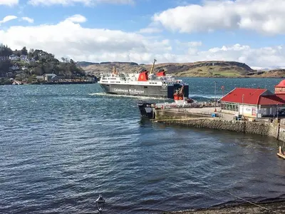 a boat is docked at a dock in the water at Imperial Apartment in Oban