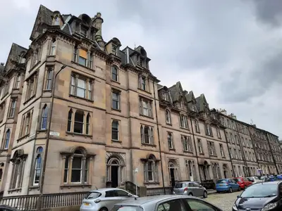 a large building with cars parked in front of it at Cornwall Street - 297 in Edinburgh