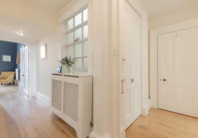 a white hallway with a door and a window at Saxe Coburg Place - 325 in Edinburgh