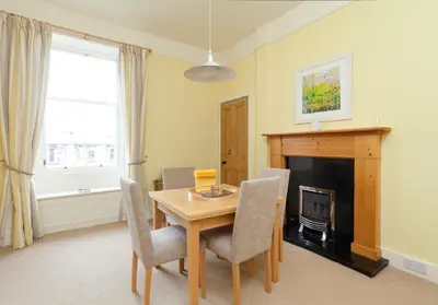 a dining room with a table and a fireplace at Mardale Crescent - 380 in Edinburgh