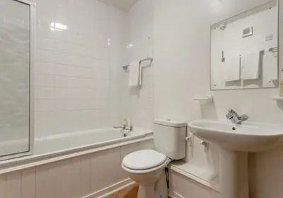 a white bathroom with a toilet and a sink at Dean Path - 400 in Edinburgh