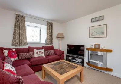 a living room with a red couch and a fireplace at Dean Path - 400 in Edinburgh