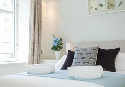 a bedroom with a white bed with pillows at Thistle Street - 401 in Edinburgh
