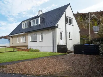 a white house with a black roof at Seaview Cottage in Ellanbeich