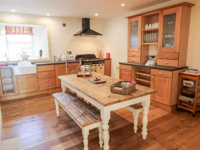 a kitchen with a wooden table in the middle at The Roundhouse in Auchterarder