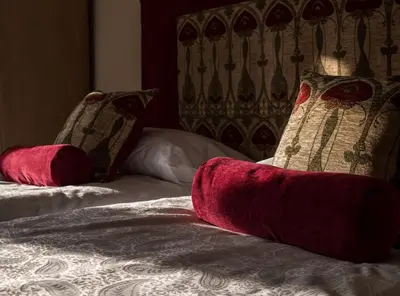 a bed with two red pillows on top of it at The Flat In The Square in Helensburgh