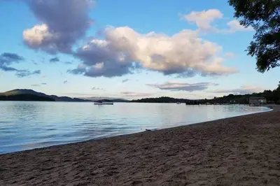 a view of a beach with a boat in the water at Broomfield Cottage South Luss in Glasgow