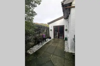 a white house with a stone walkway in front of it at Broomfield Cottage South Luss in Glasgow
