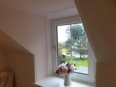 a vase filled with flowers sitting on a window sill at Cromla Cottage in Corrie