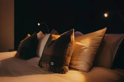 a bed with four pillows on top of it at SeaBeds - Luxury Lookouts with Hot Tubs in Glencoe