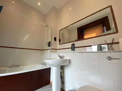 a bathroom with a sink and a toilet and a mirror at No6 West Coates in Edinburgh