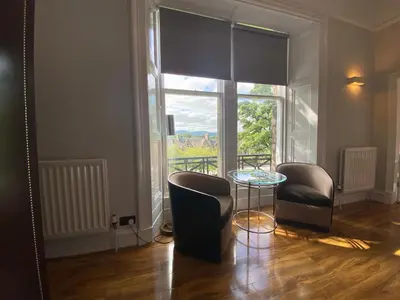 a room with two chairs and a table and a window at No6 West Coates in Edinburgh