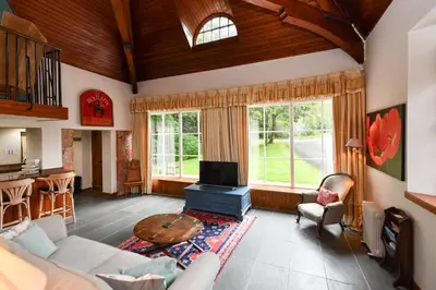 a living room with a couch and a tv at Cloncaird Castle Estate Cottages in Maybole