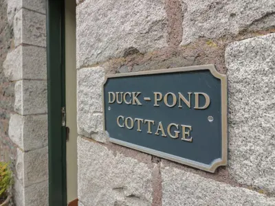 a sign on a brick wall with the words duck pond coffee at Cloncaird Castle Estate Cottages in Maybole