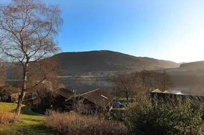 a view of a lake with a house and a mountain at Cosy Modern Nordic Lodge w/ Loch View & Log Burner in Lochearnhead