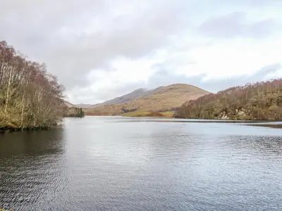 a view of a river with mountains in the background at Glenfinglas Dam Cottage in Callander