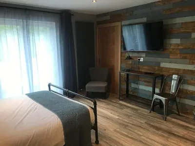 a bedroom with a bed and a desk and a television at The Shack & Pods at Inchree in Corran