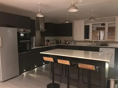 a kitchen with black and white cabinets and a counter at The Shack & Pods at Inchree in Corran
