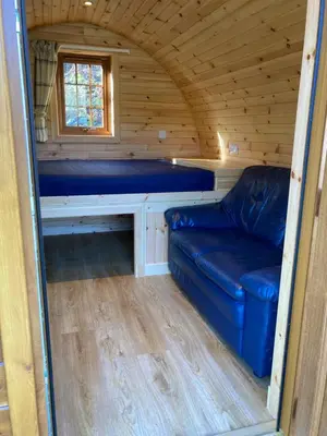 a living room in a tiny house with a couch at Posh Pod in Tyndrum