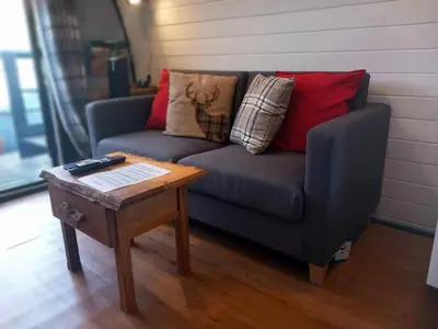 a living room with a couch and a coffee table at Etive Pod, West Highland Way Holidays in Kinlochleven