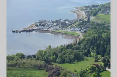 an island in a body of water with houses and trees at The Curling Pond, Dalmally Road, Inveraray in Inveraray