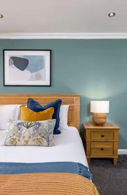 a bedroom with a bed and a lamp on a night stand at The Stirling Townhouse in Stirling
