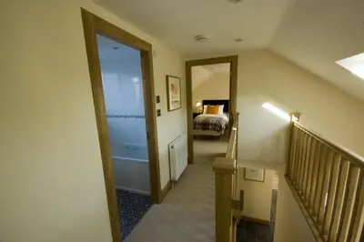 a hallway with a staircase leading to a bedroom at Harviestoun House in Dollar