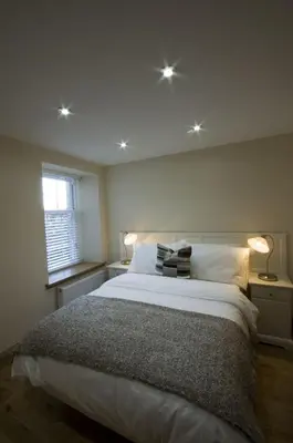 a bedroom with a large bed and a window at Harviestoun House in Dollar