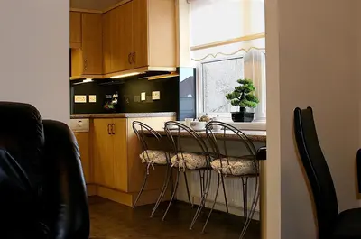 a kitchen with a table with chairs and a window at Linden Apartment in Stirling