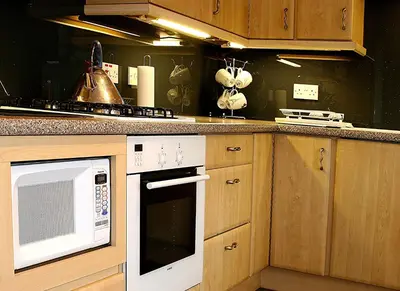 a kitchen with a stove and a microwave at Linden Apartment in Stirling