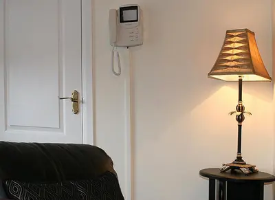 a lamp on a table next to a door with a phone at Linden Apartment in Stirling