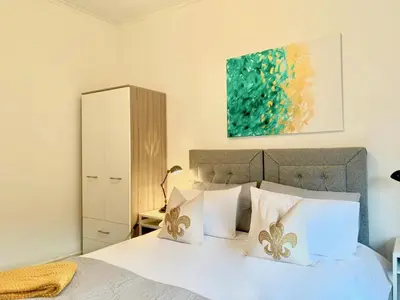 a bedroom with a white bed with white pillows at Hillington Central in Glasgow