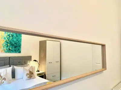 a large mirror on the wall of a bedroom at Hillington Central in Glasgow