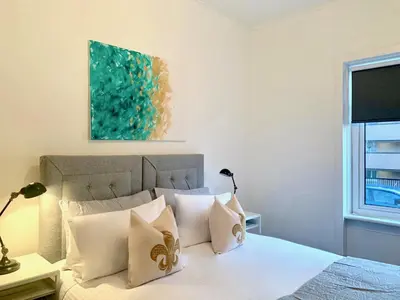 a bedroom with a bed with white sheets and pillows at Hillington Central in Glasgow