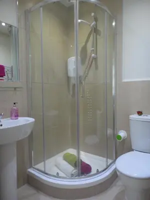 a shower with a glass door in a bathroom at Palmerston Suites in Edinburgh