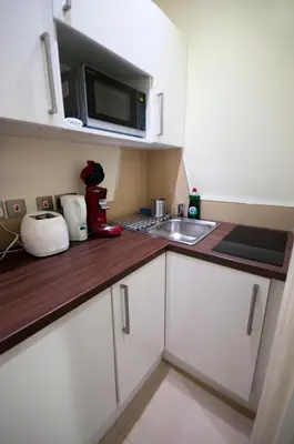 a small kitchen with a sink and a microwave at Palmerston Suites in Edinburgh