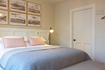 a bedroom with a large bed with pink pillows at Ross Lodge in Comrie