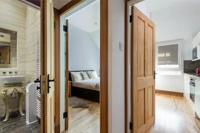 a bedroom with a bed and a sink and a door at Castle Vista, Grassmarket Apartment in Edinburgh